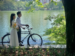Newlyweds by the Lake with a Bicycle