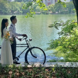 Newlyweds by the Lake with a Bicycle